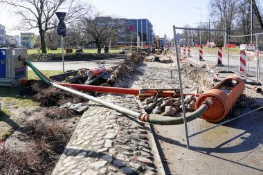 Su pompası, borular, hortumlar, uyarı işaretleri ve güvenlik bantları ile sokak onarımları su arıtma sistemi