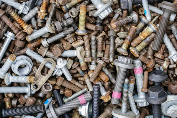 stock image Background with many new and used screws and nuts of different sizes and colors, top view