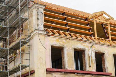 Çelik ve ahşap kirişlerle tarihi bir binanın çatı yapısının yeniden inşası. Rafterler, kiriş sistemi ve sırt kirişleri değiştirme