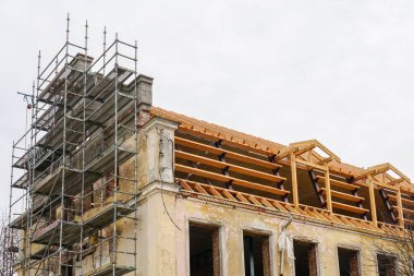 Çelik ve ahşap kirişlerle tarihi bir binanın çatı yapısının yeniden inşası. Rafterler, kiriş sistemi ve sırt kirişleri değiştirme