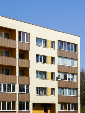 Yenilenmiş ve termal izole edilmiş renkli çok katlı apartman ön tarafı mavi gökyüzü arka planına karşı