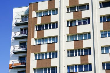 Yenilenmiş ve termal izole edilmiş renkli çok katlı apartman ön tarafı mavi gökyüzü arka planına karşı