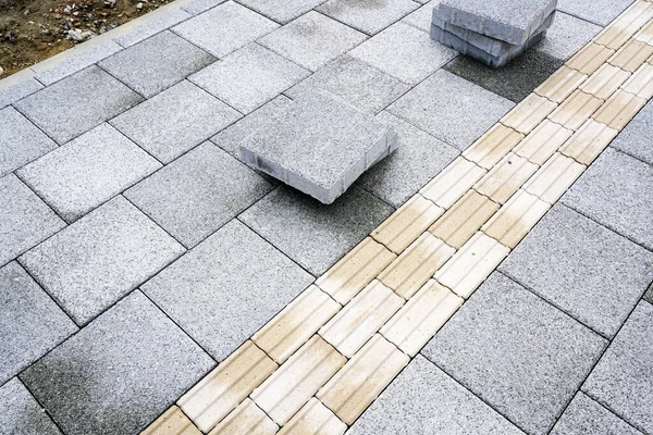 Yeni asfaltlanmış kaldırım. Görme engelliler için birleşik kılavuz ilkeler, dokunsal kaldırımlar.