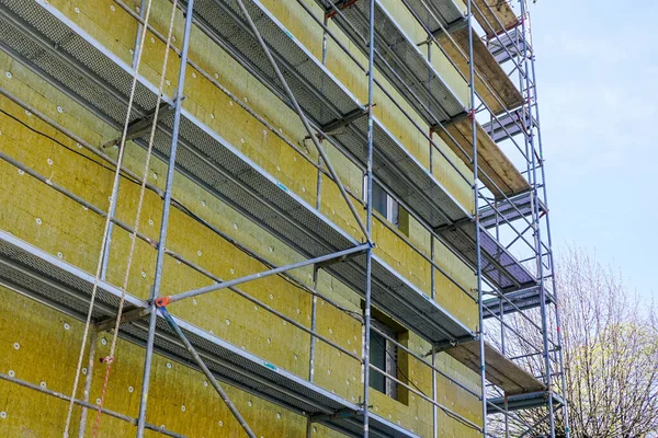 青空の背景を使用して厚い岩鉱物ウールスラブと複数の階建てのアパートの建物のファサードの断熱材 — ストック写真