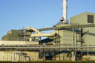 Büyük modern biyokütle eş-üretim enerji santrali, ahşap çip güç santrali, mavi gökyüzü arka planı donanımı dış görünüm