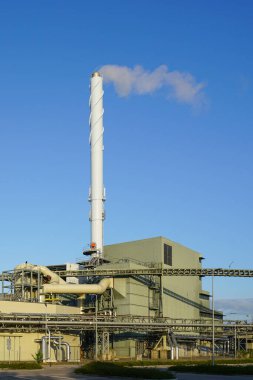Büyük modern biyokütle eş-üretim enerji santrali, ahşap çip güç santrali, mavi gökyüzü arka planı donanımı dış görünüm