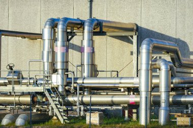 Isı üretim tesisi binasının dışındaki çeşitli paslanmaz çelik borulardan oluşan karmaşık bir sistem.