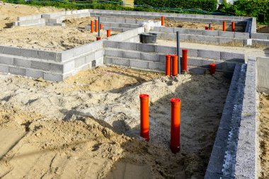 Tesisat sisteminin eş zamanlı kurulumuna sahip beton bloklardan evin temelleri oluşturuluyor