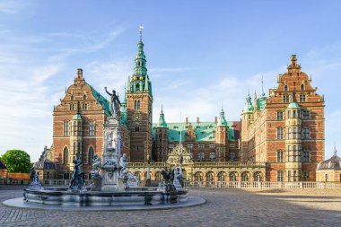 Danimarka Hillerod 'daki Frederiksborg kalesinin ön cephesinde Neptune Çeşmesi, mavi gökyüzü arka planı