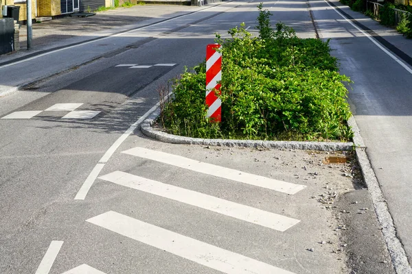 Kentte, dikey kırmızı ve beyaz çizgili uyarı işareti, yağmur bahçeleri, Danimarka ve Avrupa 'da zorunlu hız azaltımı için caddenin kenarında yeşillik var.