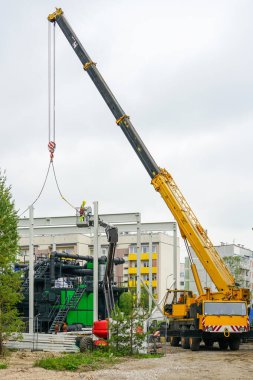 Teleskopik patlama vinci kullanarak yeni modern ahşap yonga biyoyakıt kazanının etrafına monte edilen metal çerçeve.