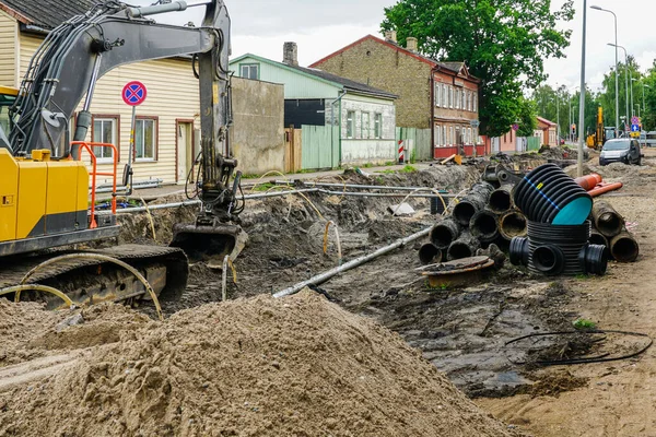 stock image Street reconstruction view with deep trench, old and new underground pipes, new vertical plastic well