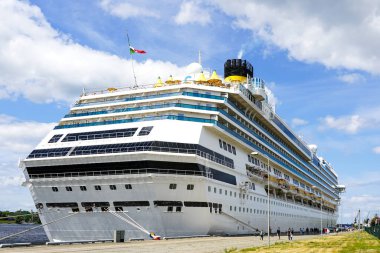 Limanda turist taşıyan büyük beyaz yolcu gemisi, dikiz manzaralı, mavi gökyüzü arka planı