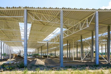 Güçlendirilmiş beton destekli, kıvrımlı çelik çatılı yeni bir ticari binanın yapısal çelik yapısı.
