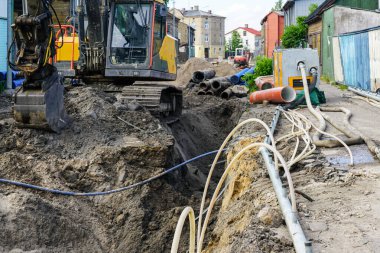 Sokak yeniden inşa manzarası, derin siper, su arıtma sistemi, yeni ve eski borular, plastik kuyu, kazıcı, boru hattı değiştirme