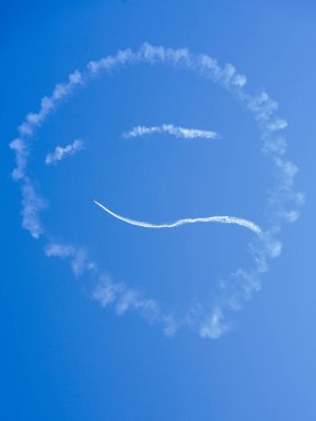 Mavi gökyüzünde gülen yüz şekli uçak beyaz duman izleriyle yaratıldı aero gösterisi sırasında, yüzü gökyüzünde