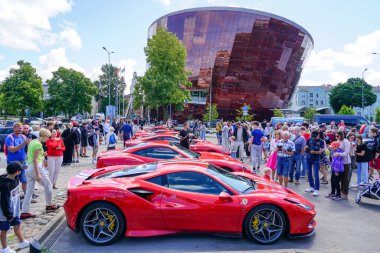 Liepaja, Letonya - 20 Temmuz 2023: Avrupalı Ferrari otomobil sahibi ön planda Ferrari F8, arka planda Great Amber City konser salonu