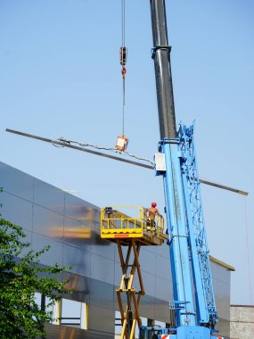 Sandviç panelleri duvar ve çatı montajı teleskopik patlama vinç ve kendinden itişli makas kaldırma, mavi gökyüzü arkaplanı