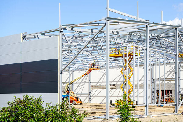 Complex large volume steel frame structure assembly using self propelled scissor lift and articulating boom lift platforms