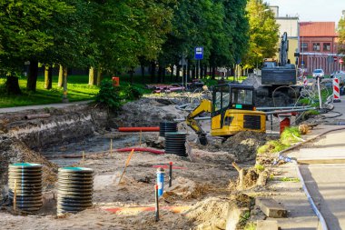 Street reconstruction view, replaced underground pipes, vertical plastic wells, dewatering system, excavators, deep and wide trench, digging works clipart