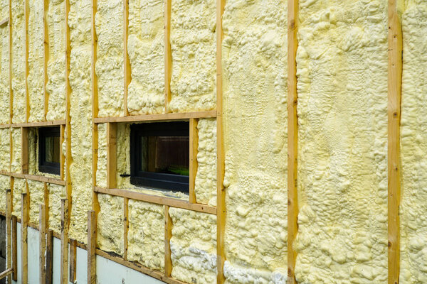 The facade of the residential house sprayed with a layer of polyurethane thermal insulation foam before siding with wooden planks