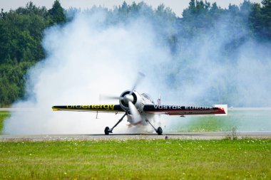 Liepaja, Letonya - 06 Ağustos 2023 - Aerobatik Litvanyalı pilot Jurgis Kairys Sukhoi SU-31 uçağıyla pistte dumanlı bir bulutun içinde