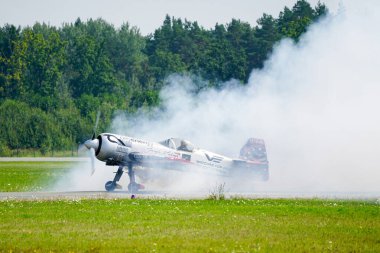 Liepaja, Letonya - 06 Ağustos 2023 - Aerobatik Litvanyalı pilot Jurgis Kairys Sukhoi SU-31 uçağıyla pistte dumanlı bir bulutun içinde