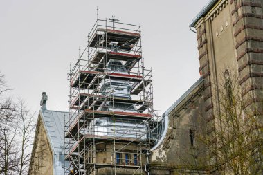 Eski bir Lüteriyen duvarcılık kilisesinin teneke çatı döşemesini karmaşık bir yapı iskelesi kullanarak yenilemek.