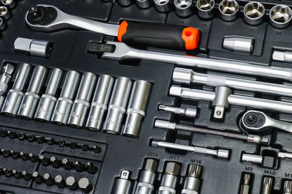 Tool box, tool kit closeup with set of hex, torx and screwdriver bits, and various sizes of ratchet wrench sockets