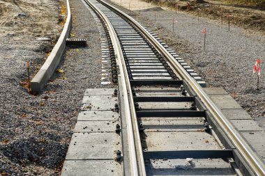 Yeni tramvay raylarını, titreşim ve gürültü salınımını azaltan poliüretan pedlerle yeni beton yataklı vagonlara yerleştirmenin yanı sıra rayları izole ediyor.