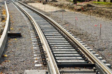 Yeni tramvay raylarını, titreşim ve gürültü salınımını azaltan poliüretan pedlerle yeni beton yataklı vagonlara yerleştirmenin yanı sıra rayları izole ediyor.