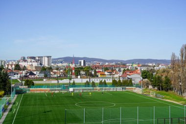 Güzel Bratislava şehri ilkbaharın başlarında güneşli bir sabah ve yeşil futbol sahası ön planda