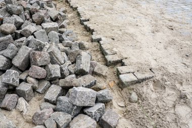 Tarihi çekiçle döşenmiş granit kaldırım taşları, şehir yüzeyi restorasyonu, küp kayalar.