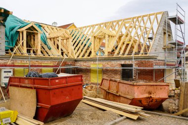 Reconstruction of an old brick house, replacement of wooden roof structures, historical house restoration, construction waste containers