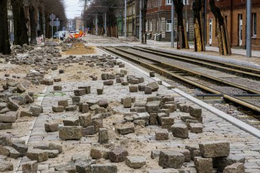 Sokak yeniden yapılandırmasının perspektif görüntüsü, tahta kapaklı ağaç gövdeleri koruma, yeni değiştirilmiş tramvay rayları, bitmemiş doğal granit kaldırım