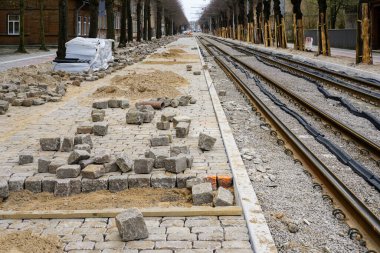 Sokak yeniden yapılandırmasının perspektif görüntüsü, tahta kapaklı ağaç gövdeleri koruma, yeni değiştirilmiş tramvay rayları, bitmemiş doğal granit kaldırım