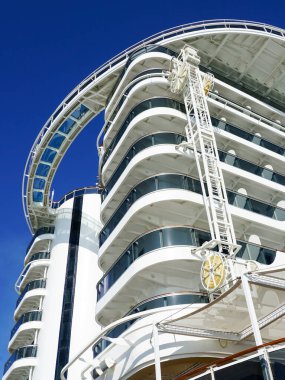 Mavi gökyüzü arka planında kamaraları olan lüks bir yolcu gemisinin kıç tarafında. Geminin gövde yıkama tesisi.