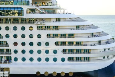 Büyük çoklu güverte yolcu gemisi yan görüş parçası. Güverte delikleri yuvarlak, balkonlar ve korkuluklu kamaralar.