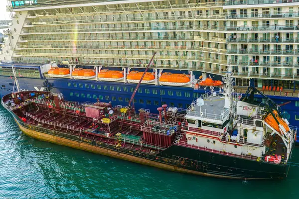 stock image Barcelona, Spain - May 25, 2024: large cruise liner Celebrity Equinox being refueled by a fuel tanker at Barcelona harbor passenger terminal