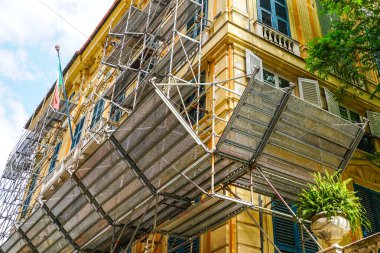 Tarihi bir evin ön cephesinde metal ızgara koruyucu plakalı prefabrik metal boru.