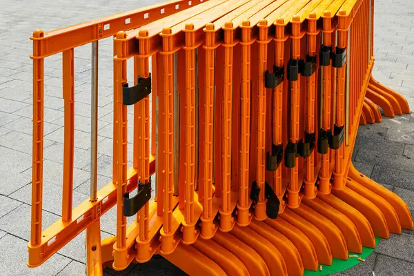 stock image Movable foldable temporary orange plastic lightweight barrier sections for regulating people flow at outdoor events