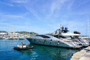 Cannes, Fransa - 26 Mayıs 2024: Lüks tekne ve yatlarla Cannes limanında yaz günü, mavi gökyüzü geçmişi