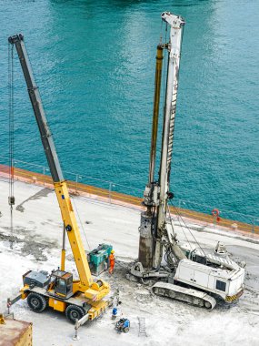 Installation of pile casings in the port quay, drilling rig machine, port infrastructure upgrade works in the quay of the port of Genoa, Italy clipart