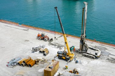 Installation of pile casings in the port quay, drilling rig machine, port infrastructure upgrade works in the quay of the port of Genoa, Italy clipart