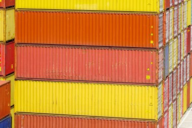 Sarı, turuncu ve kırmızı kargo konteynırları liman terminalinde çeşitli katmanlara istiflenmiş konteynırlar, liman konteynır terminalindeki konteynırlar.