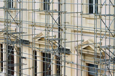 Evin ön cephesinde modern metal boru iskelesinin inşaatı