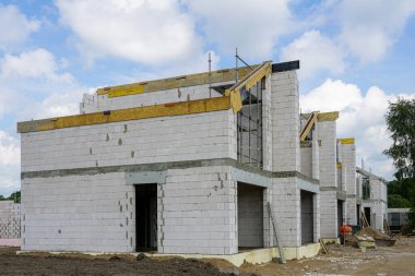 Construction site of a new residential terraced house from expanded clay blocks, thermally insulated foundations, the frame of a new house clipart