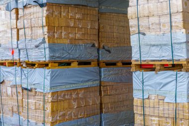 Paletlerin üzerine odun parçacıkları istiflenmiş, polietilen paketlenmiş, talaşlı eko briketler soba ve şömine için mükemmel.