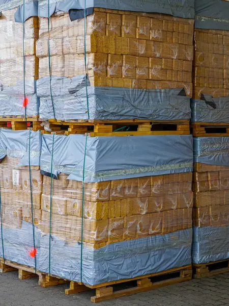 Paletlerin üzerine odun parçacıkları istiflenmiş, polietilen paketlenmiş, talaşlı eko briketler soba ve şömine için mükemmel.