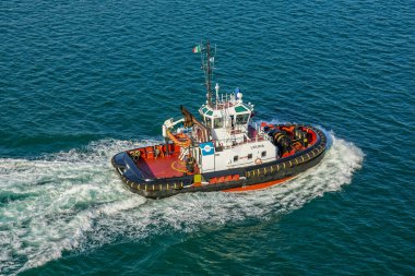 La Spezia, Italy- 28 Mayıs 2024: Mavi Akdeniz arka planında yelken açan küçük iskele pilotu Liguria beyaz köpük izi, üst görüş açısı